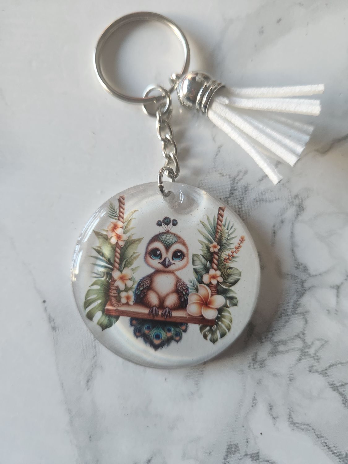 Porte clé paon sur sa balançoire