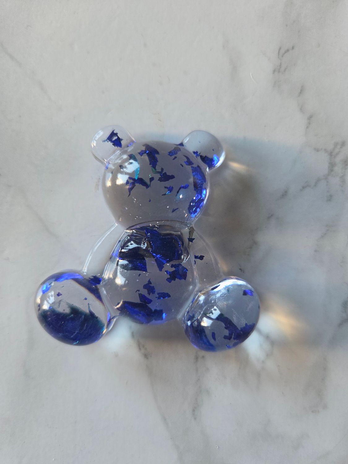 Ourson assis transparent feuilles bleu métalliques