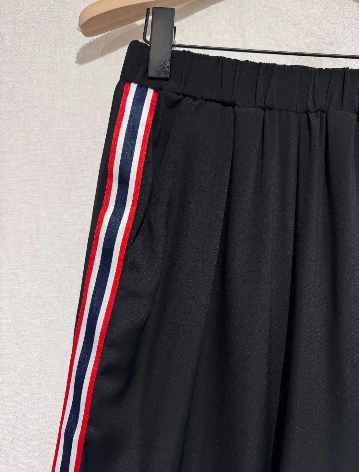 Zwarte geklede broek met zakken en rek bovenaan. Gekleurd detail aan de zijkant geeft deze broek een vlotte look.