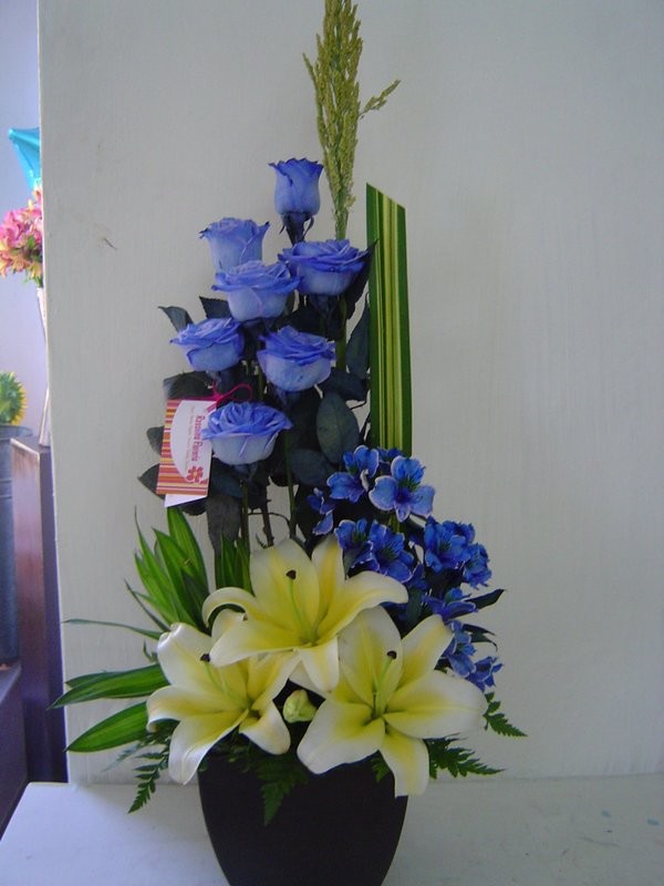 Arreglo en base cerámica con rosas azules