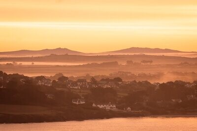 A sunrise over Daymer Bay Cornwall with views to Bodmin Moor