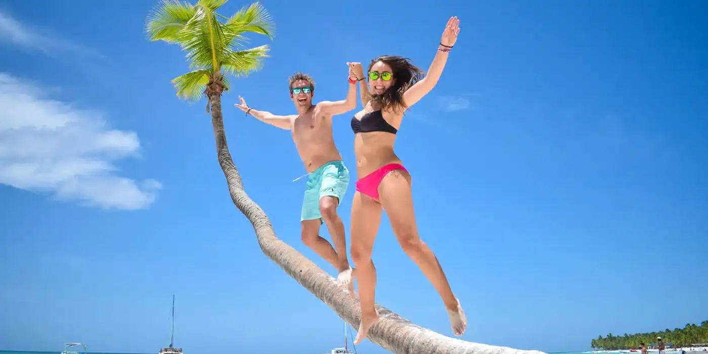 Traveler posing on a palm tree in Saona