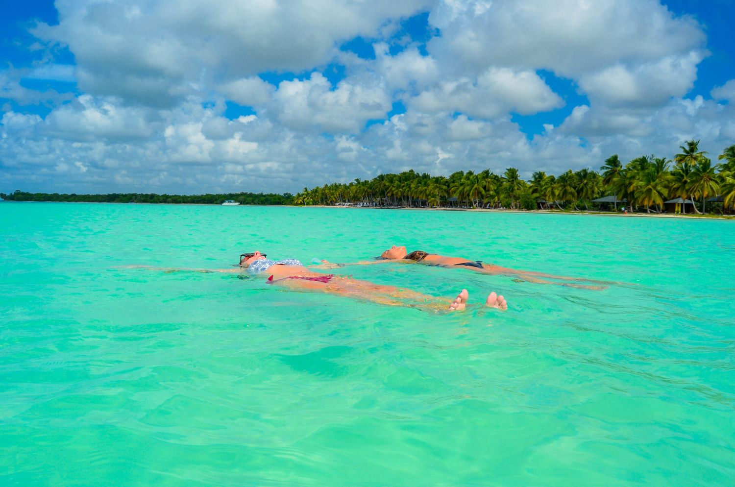 Group of travelers floating in turquoise water in Saona