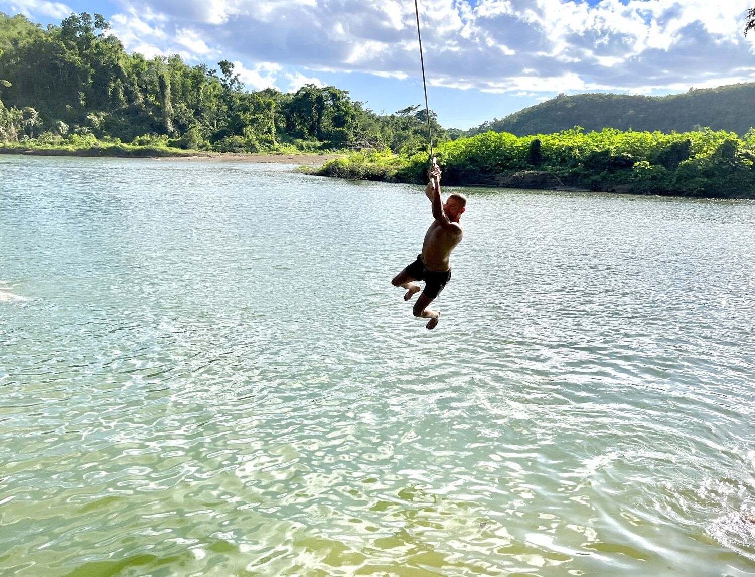 Traveler jumping into the river from a dock during the safari
