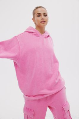 A woman wearing a pink hooded sweater