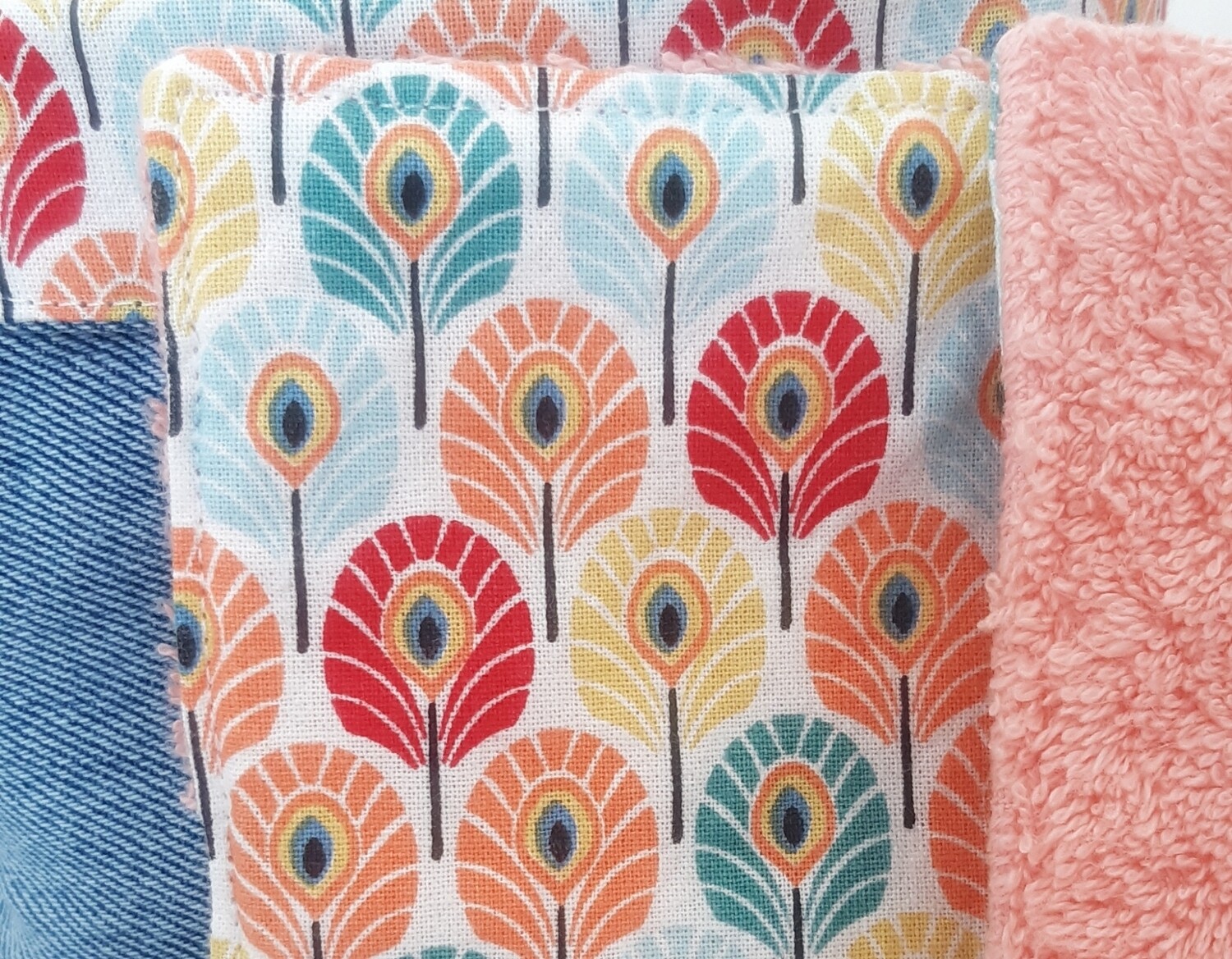 Zoom sur la couture artisanale et les couleurs des lingettes Taous – jean recyclé et coton paon