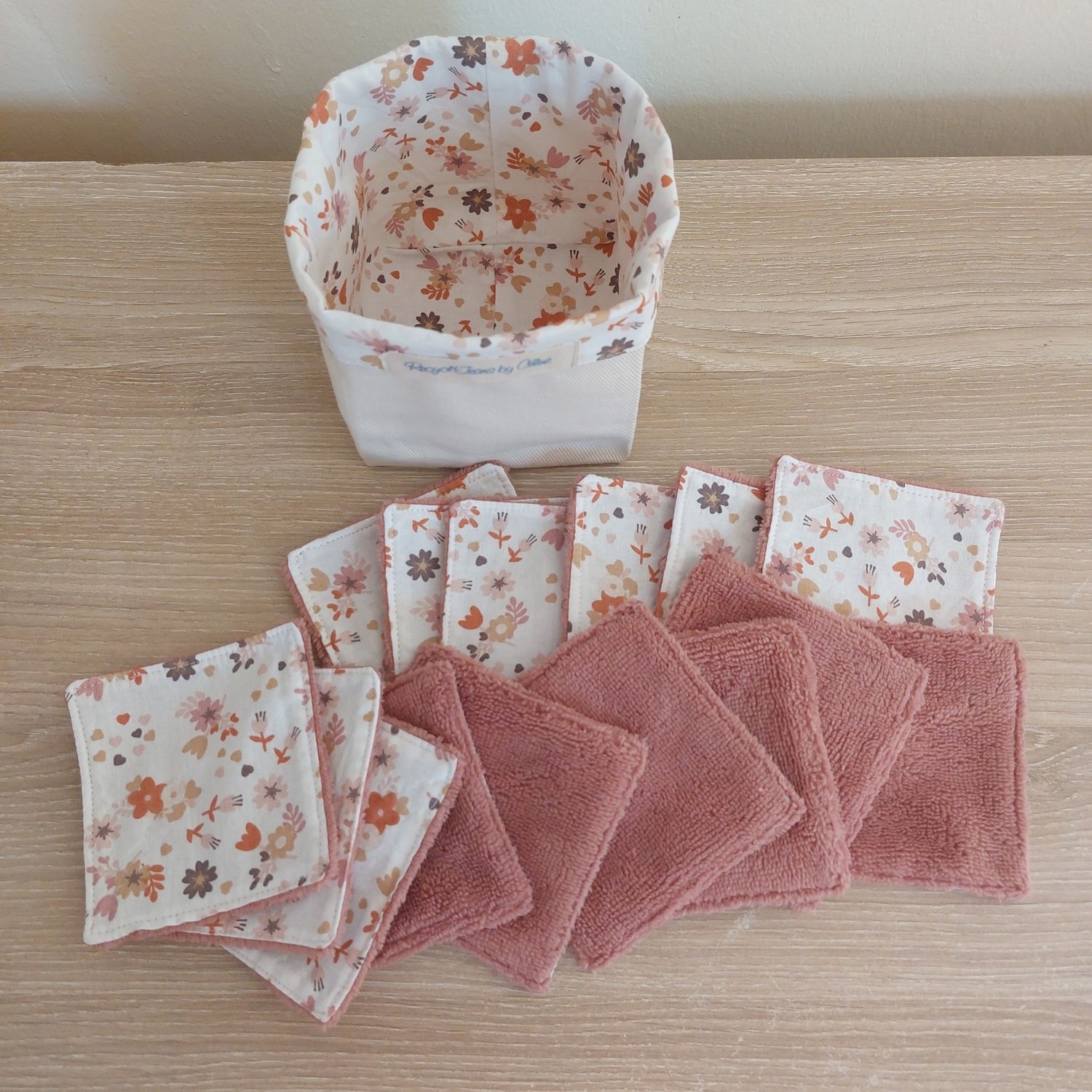 Panier Ollie en jean recyclé blanc crème et ses 15 lingettes lavables en coton fleuri et bambou vieux rose rangées devant 