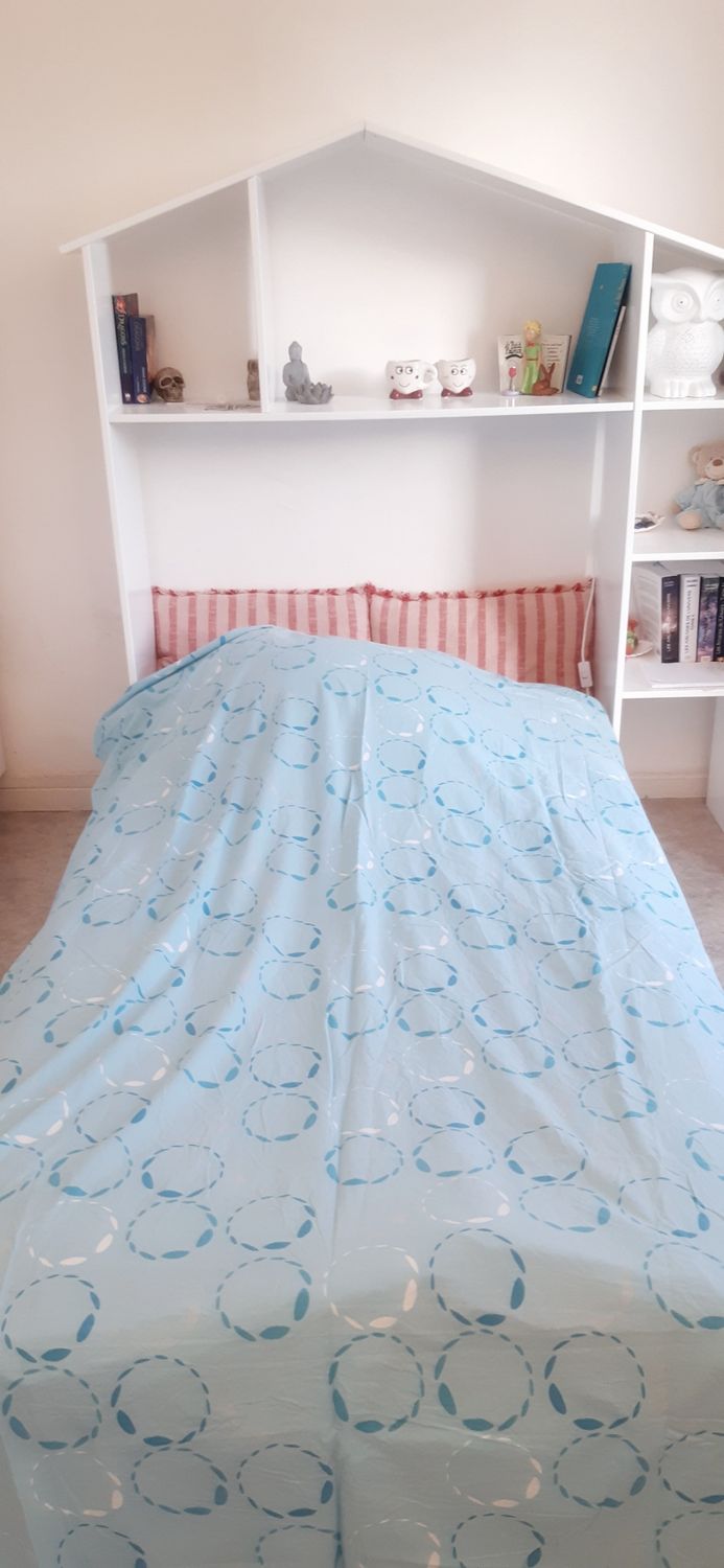 Textile revalorisé posé sur un lit – housse de couette à motifs cercles bleus et blancs