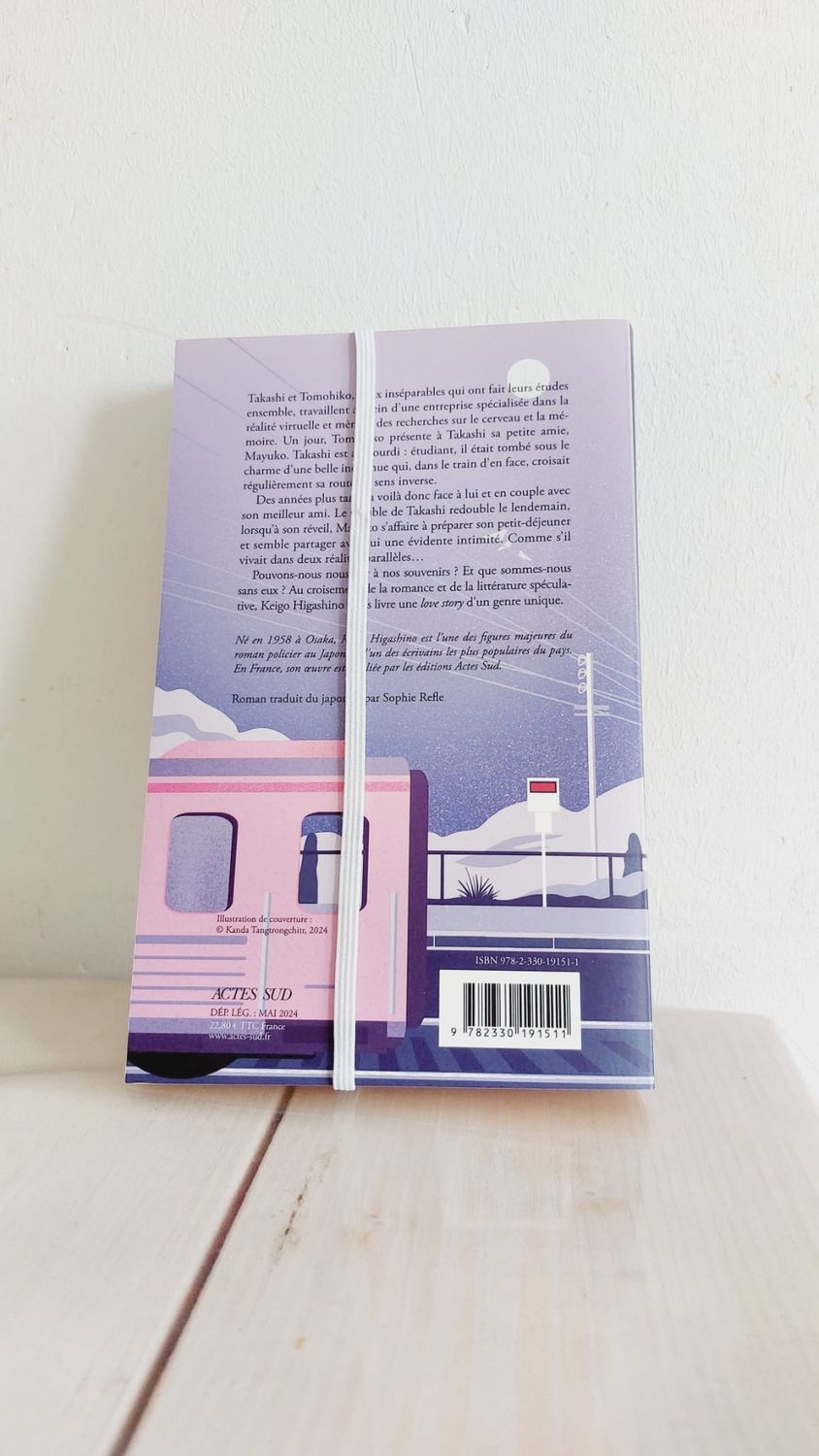 Marque-page Coquelia en place dans un livre ouvert, avec élastique fixé - vue dos du livre