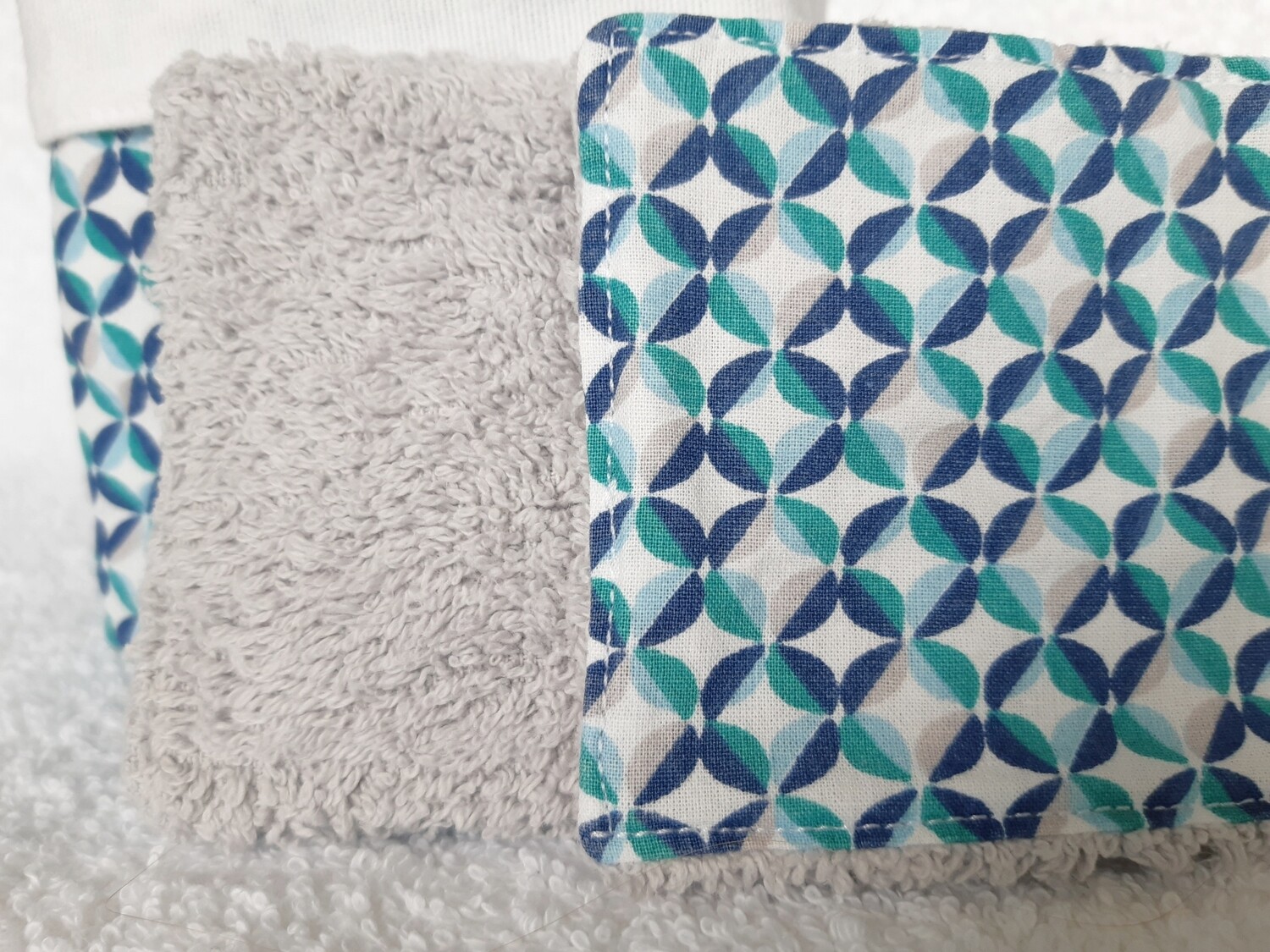 Zoom sur la couture artisanale des lingettes Pop – éponge grise et tissu pop graphique