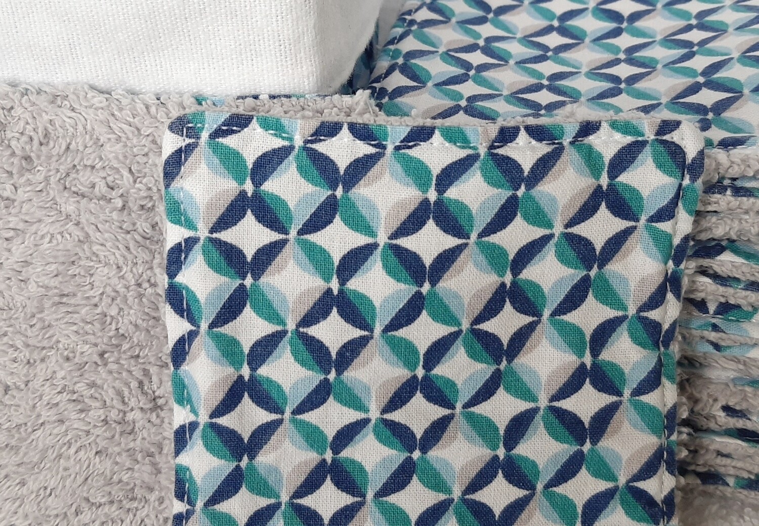 Zoom sur la couture artisanale des lingettes Pop – éponge grise et tissu pop graphique