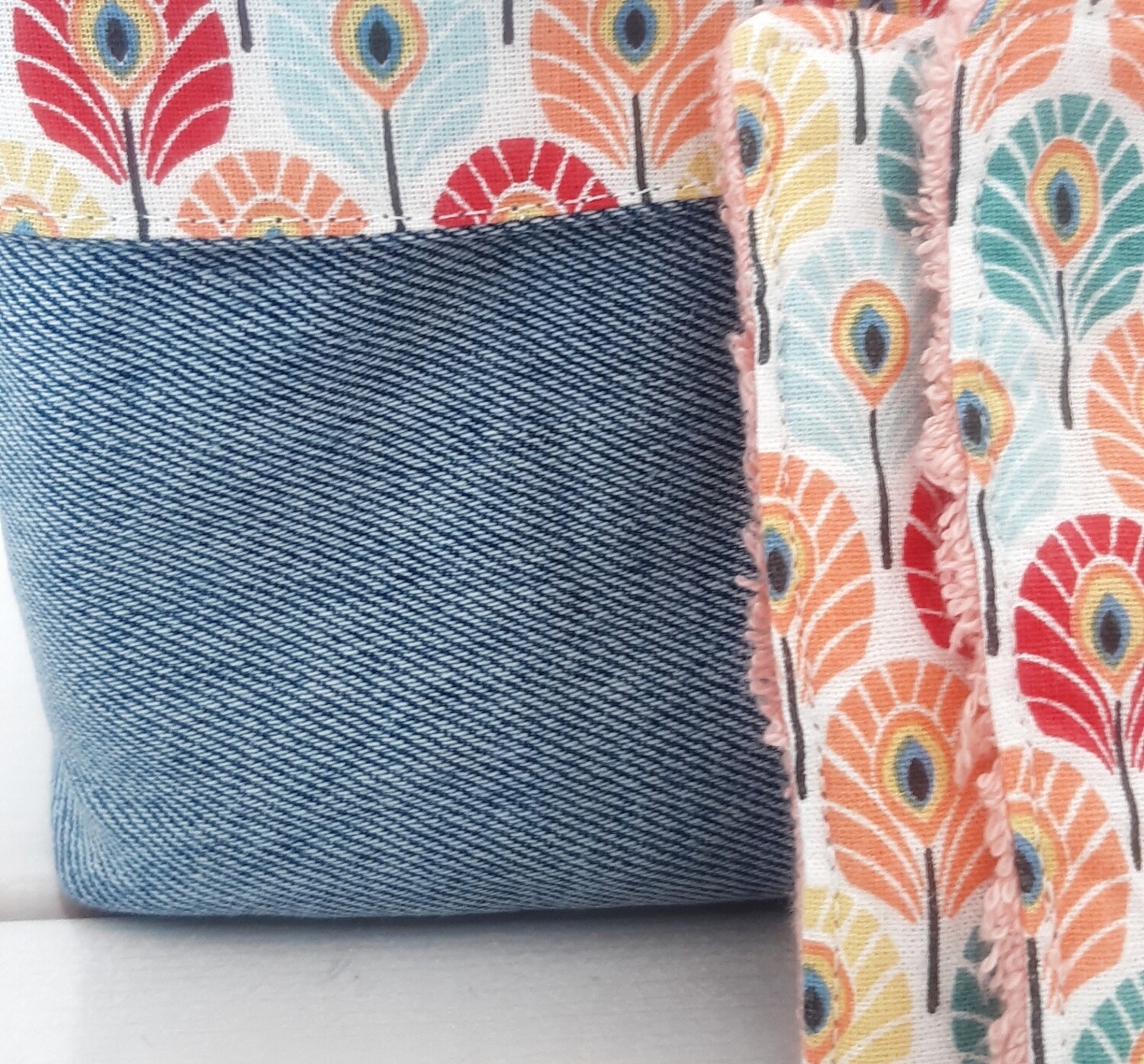 Zoom sur la couture artisanale du panier Taous – jean recyclé et tissu paon" et la couleur des lingettes
