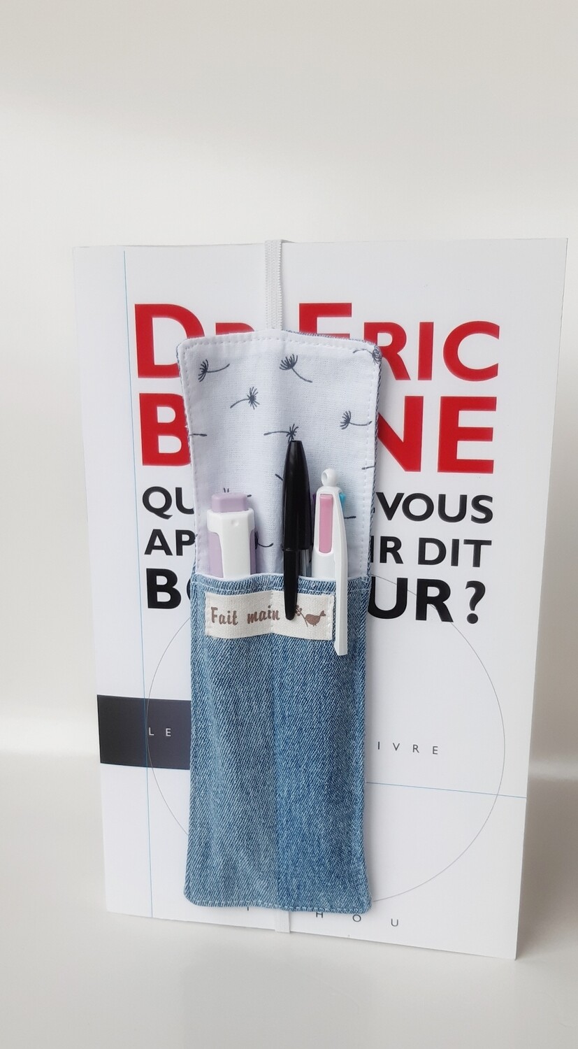 Marque-page Hanu cousu main en jean recyclé et tissu coton, posé sur un livre grand format