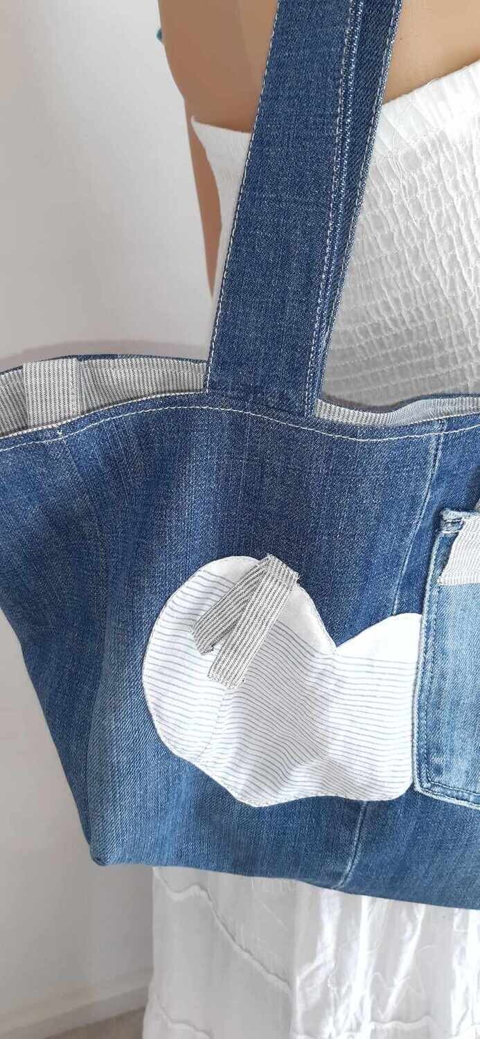 Zoom sur les motifs coeur à l'extérieures du sac Anthelme – jean délavé et détails en chemise recyclée