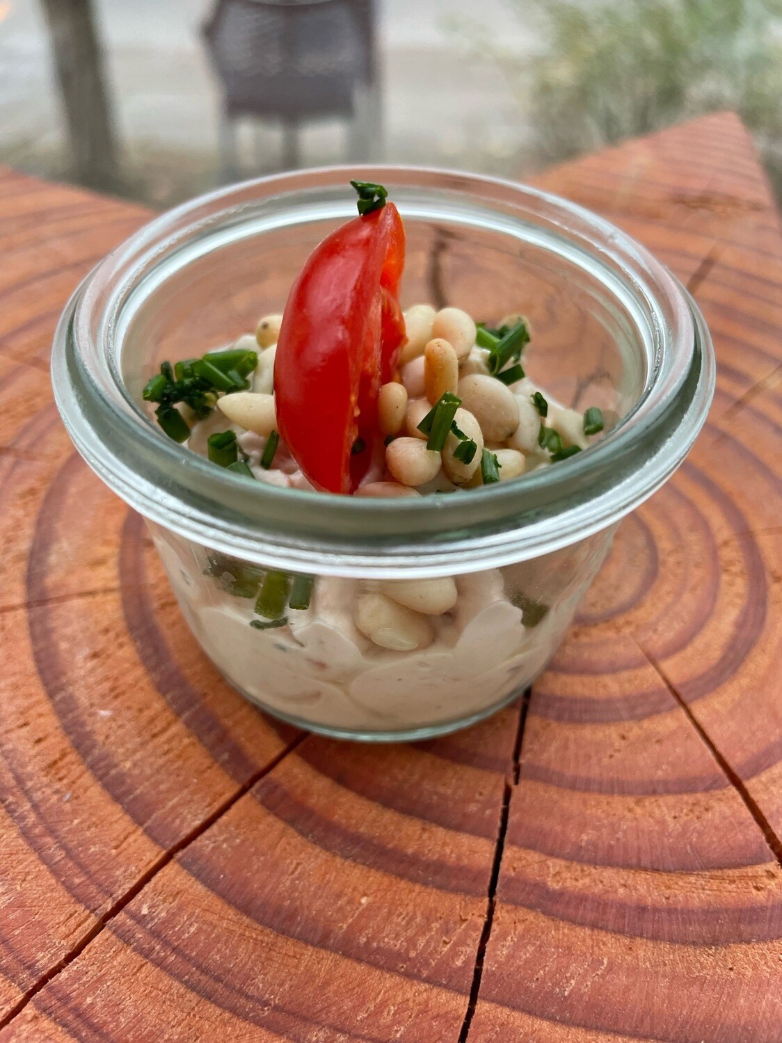 Hausgemachter Frischkäse mit Basilikum, getrockneten Tomaten und Pinienkernen