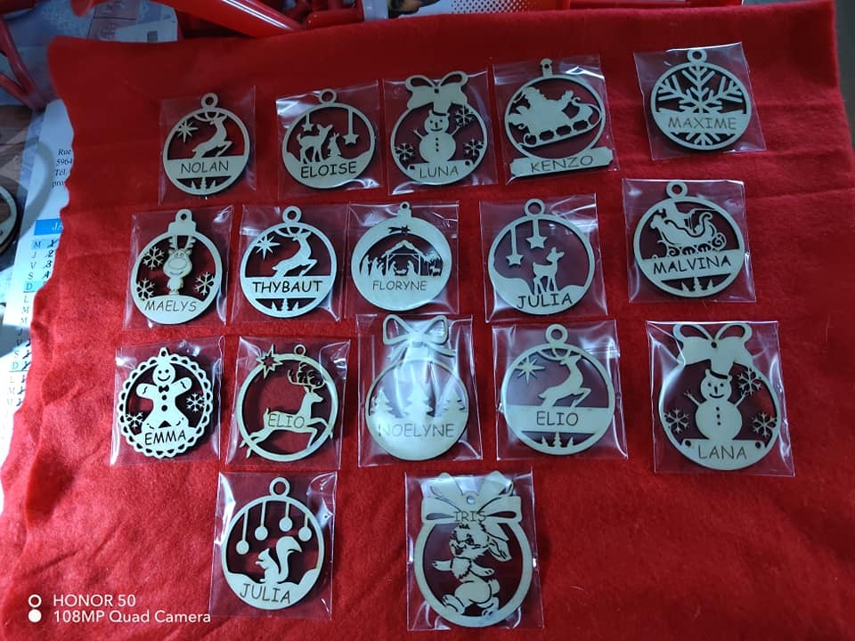 Boule de Noël en bois personnalisée avec texte et motif découpés laser