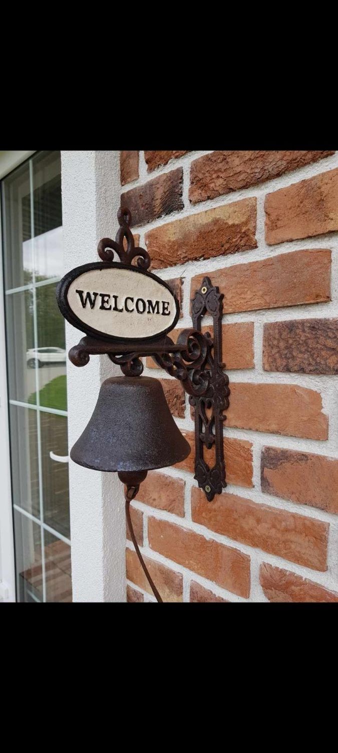 Metalinis varpas su užrašu "Welcome"