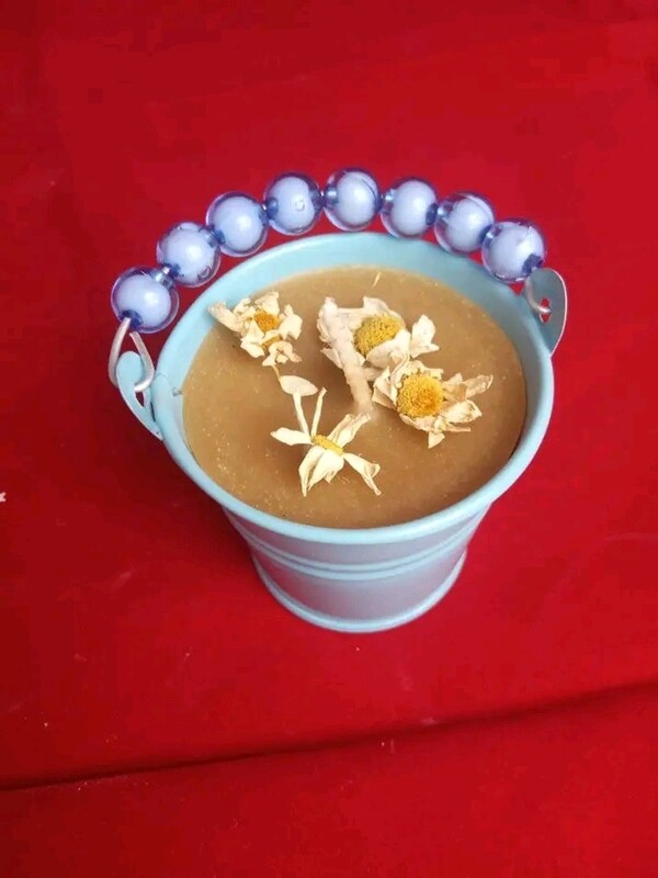 Beeswax candle  in a container with chamomile