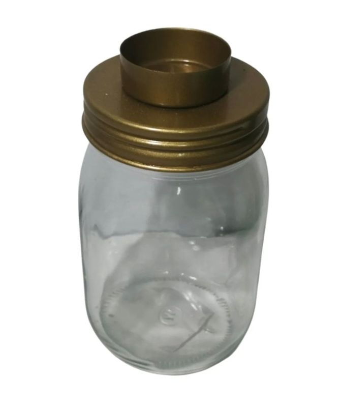 Glazen bokaal met goudkleurige deksel met theelicht.
