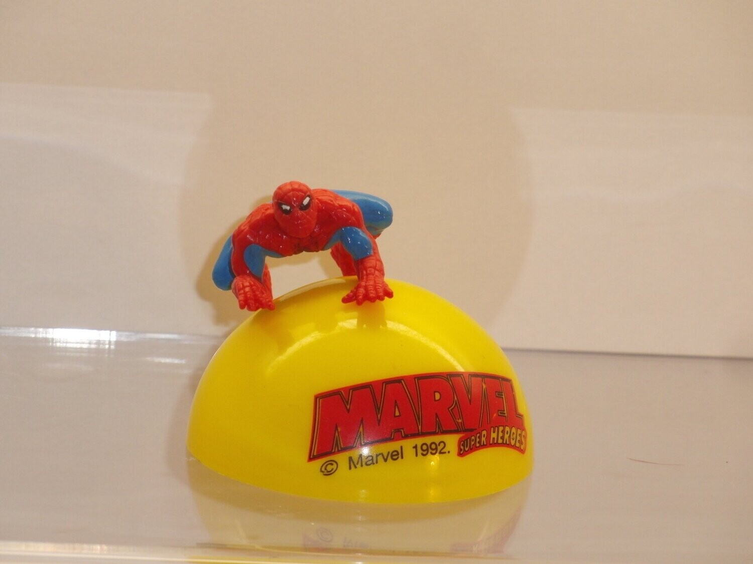 Marvel Super Heroes: 1992: Spiderman
Figur auf gelber Halbkugel mit Schriftzug (Figur ist auf Kugel gesteckt)