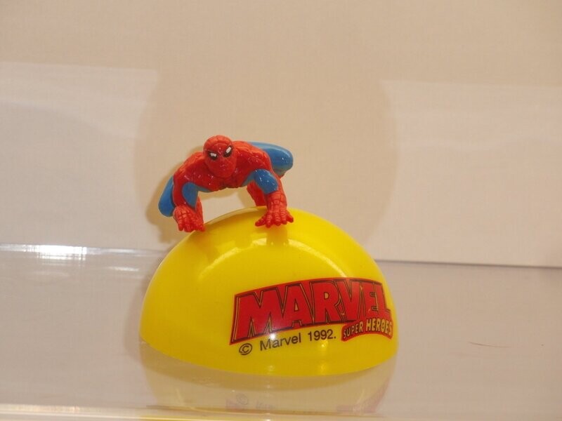 Marvel Super Heroes: 1992: Spiderman
Figur auf gelber Halbkugel mit Schriftzug (Figur ist auf Kugel gesteckt)