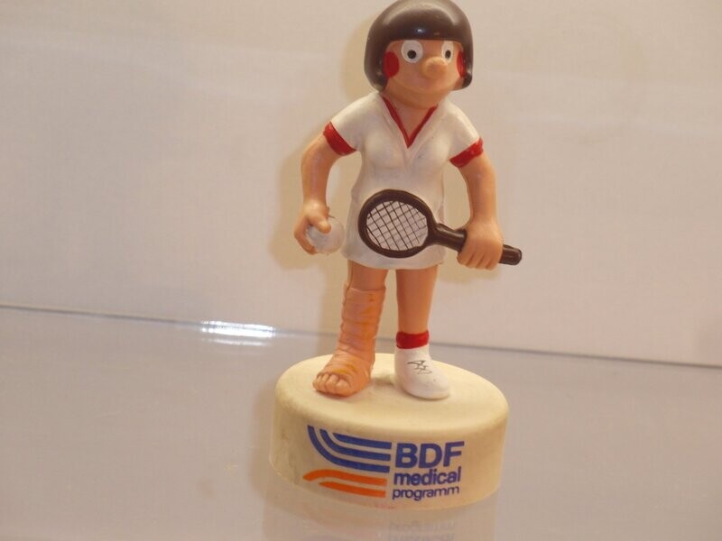 Werbefiguren: BDF medical programm: 80er Jahre: Tennisspielerin mit Verband auf Sockel