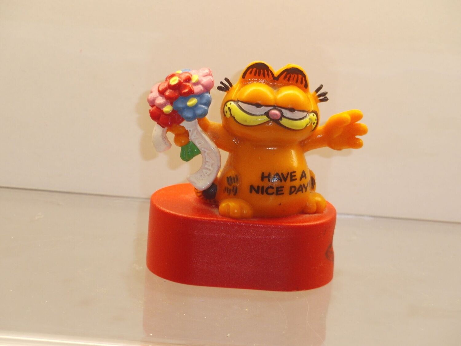 Garfield: Bully: Garfield auf Spitzer, Sockel oval: mit Blumenstrauß