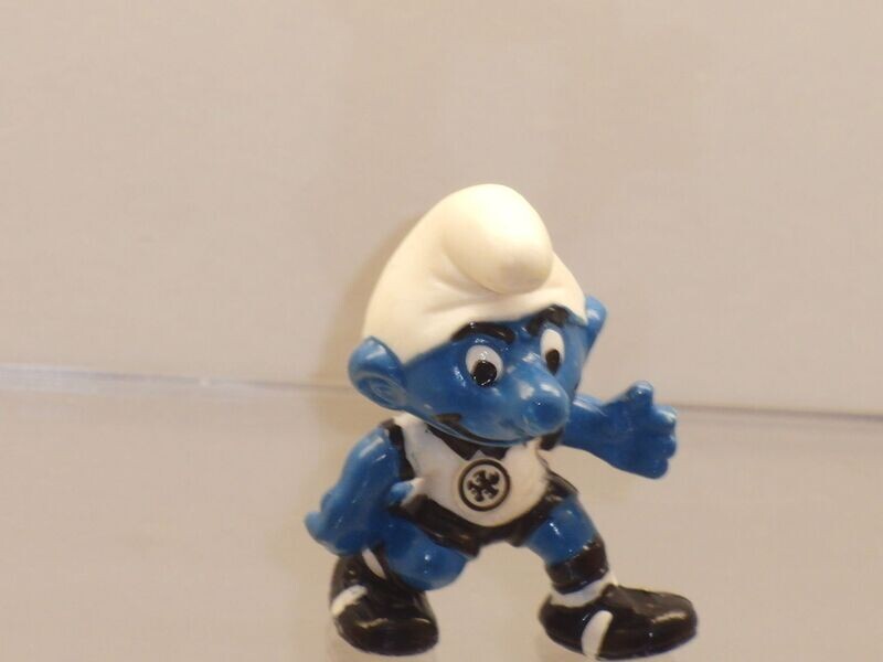 Die Fußballschlümpfe 1988: Abwehrschlumpf ohne Ball, mit Emblem Die Fußballschlümpfe 1988: Abwehrschlumpf ohne Ball, mit Emblem