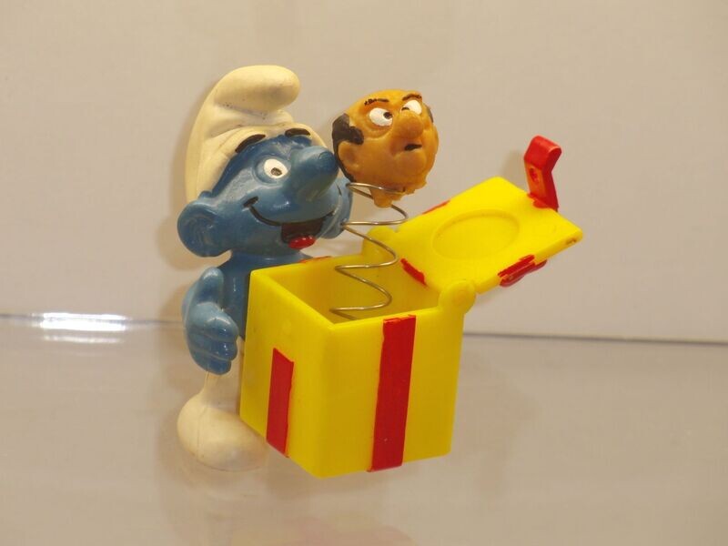 Schlumpf mit Gargamel im Kasten 4.0247
Gargamelkopf am Hals beschädigt.
Kasten war mal eingeklebt. Kleber hat sich gelöst