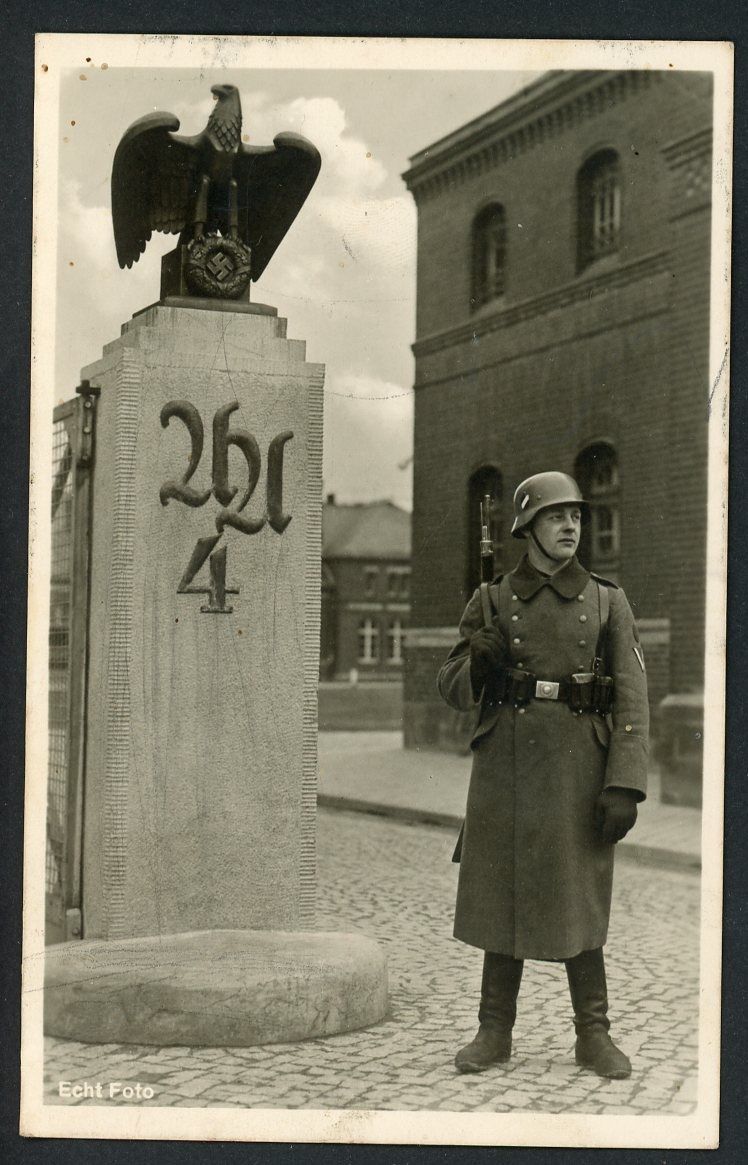 German WW2 Photo Postcard Wehrmacht Soldier Stands Guard At Aufklarungs Abteilung 4 Eagle Swaz Monument In Garrison Town of Sonderhausen