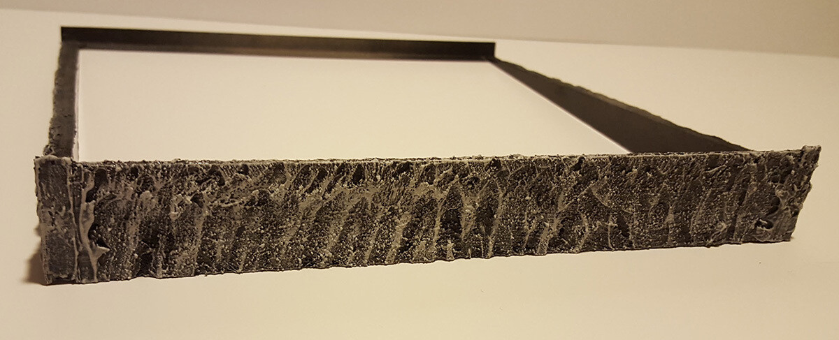 Back side of support, designed like rock face, with slim extrusion to fit between the raised tiles