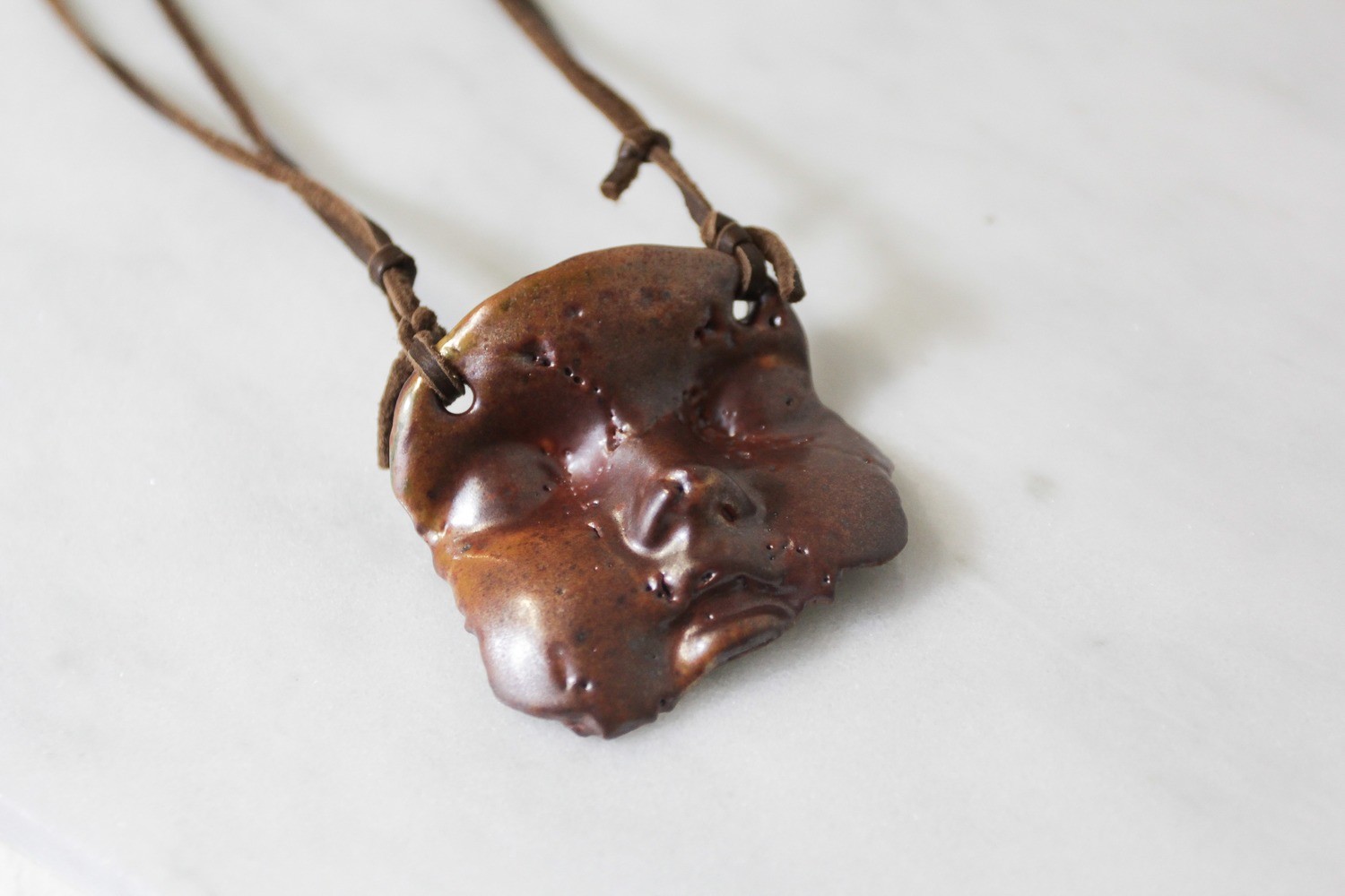 Tan chinless baby face pendant