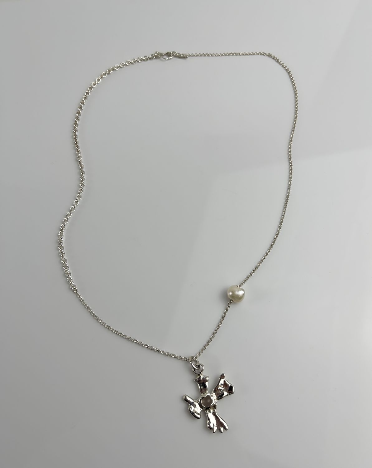 Threshold Collection: A Small Crossing Necklace with Rose Quartz