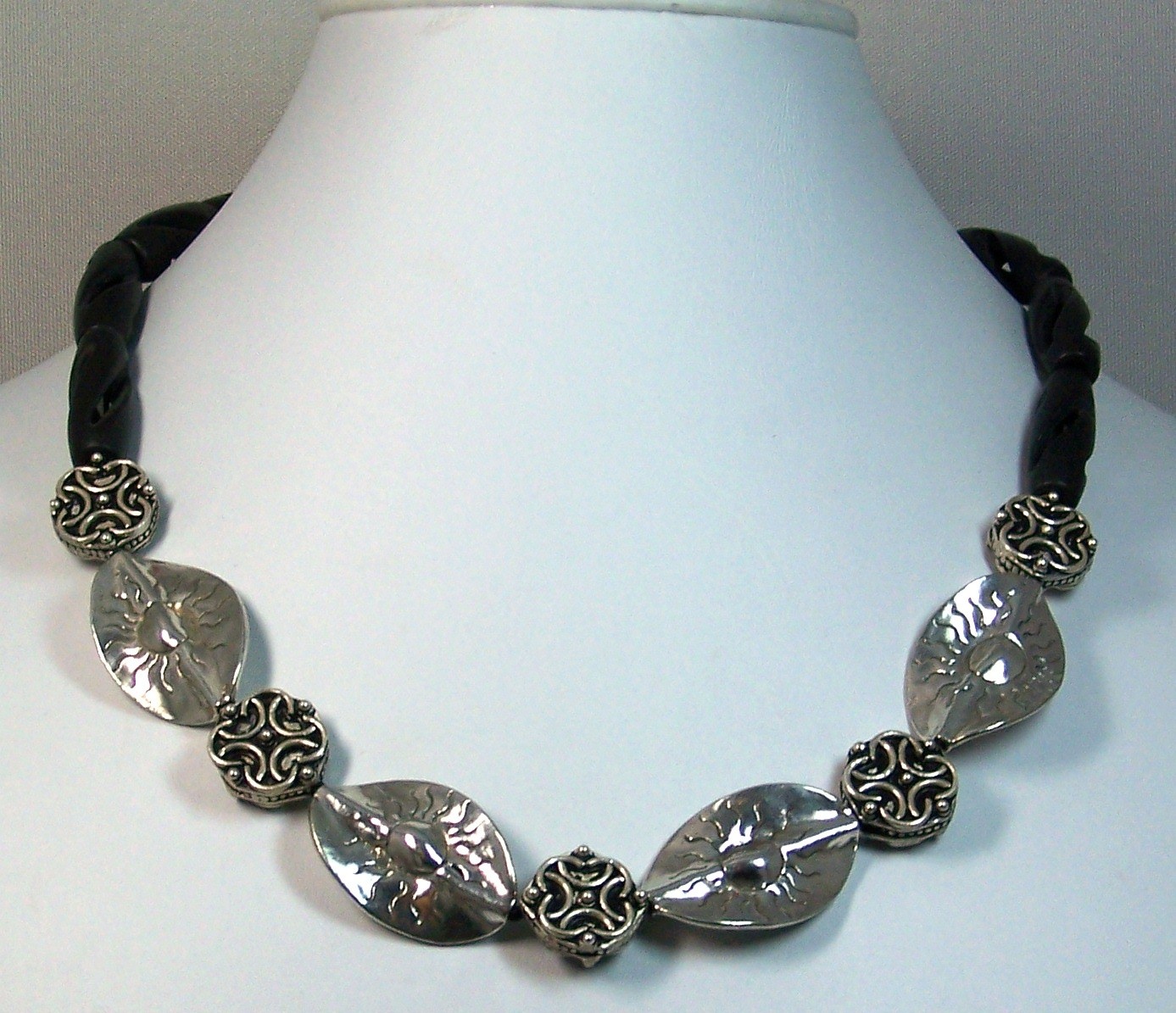 Necklace of sterling silver leaves separated by filigree silver beads , finished with twisted black stone beads