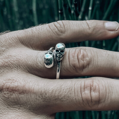 Anillo de hombre con diseño de calaveras en las terminaciones. 