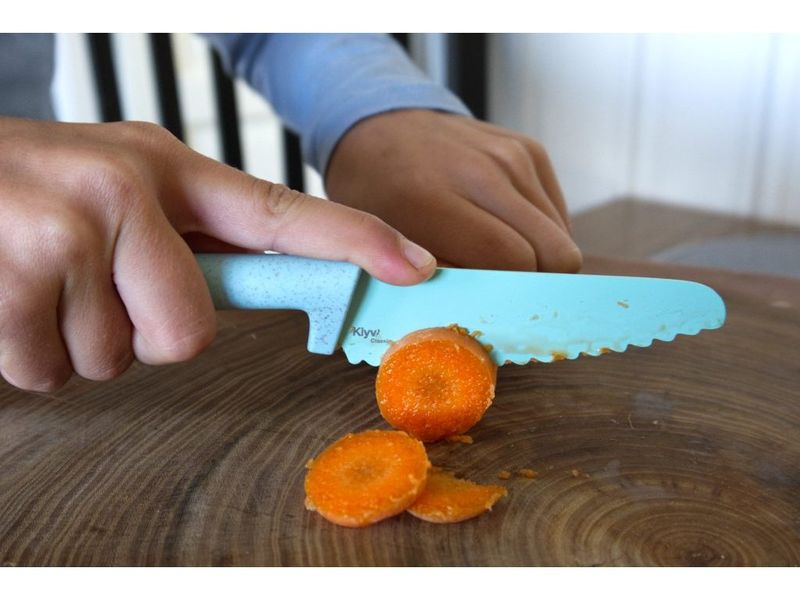 Weet je nog het moment waarop het kind voor het eerst zegt: “Ik wil ook snijden”? Wanneer kinderen beginnen te helpen in de keuken, willen ze vanzelfsprekend zoveel mogelijk volwassenen imiteren – deel uitmaken van de actie, het zelf proberen en het