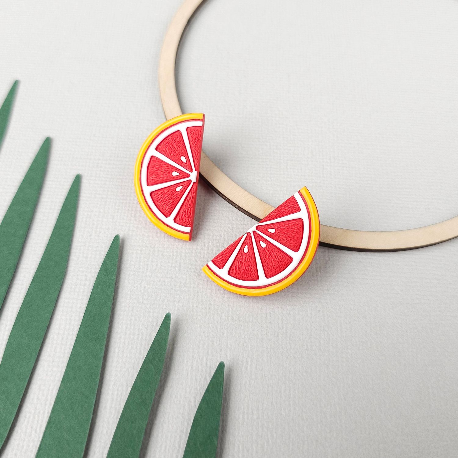 A pair of polymer clay grapefruit slice earrings.