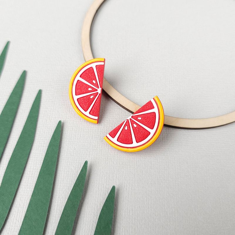 A pair of polymer clay grapefruit slice earrings.