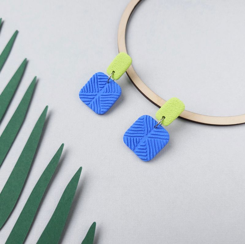 A pair of blue and green geometric textured earrings. 