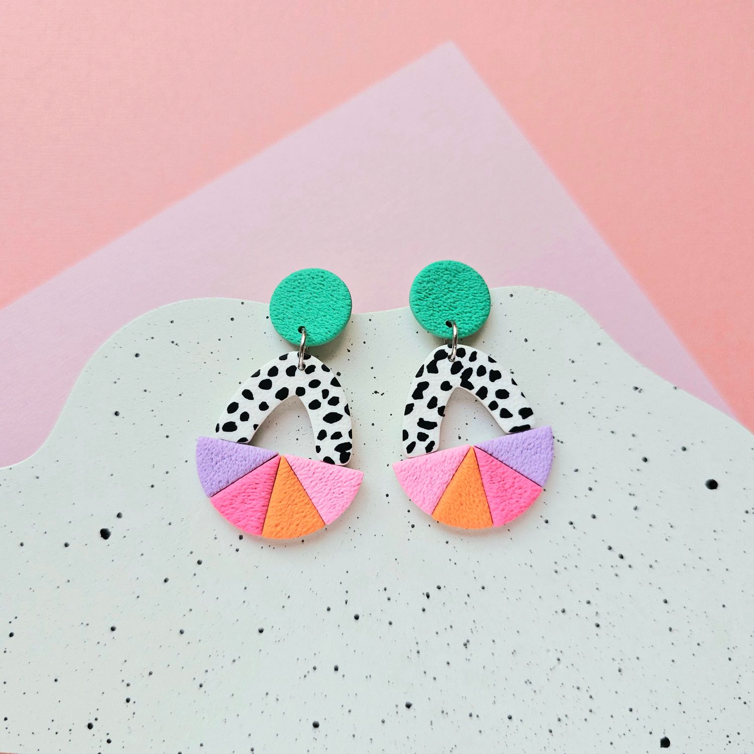 A pair of colourful dangle earrings with a geometric design, made of polymer clay