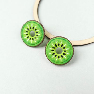 Two round, chunky hoops, green kiwi fruit slice-shaped earrings with brown edges and white and black details.