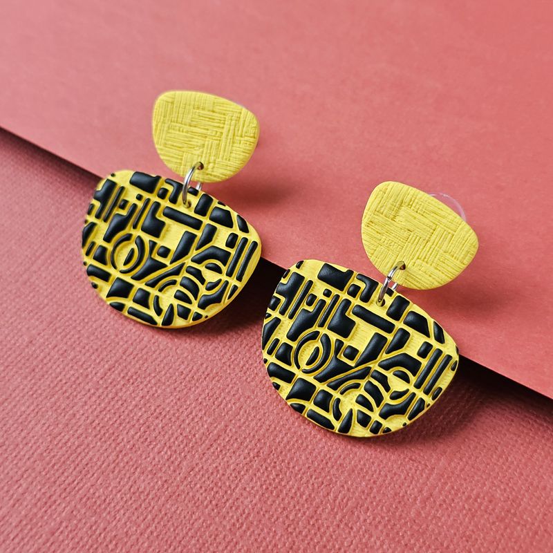 A pair of yellow and black geometric earrings