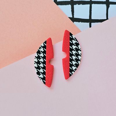 A pair of red and houndstooth pattern semicircle polymer clay earrings