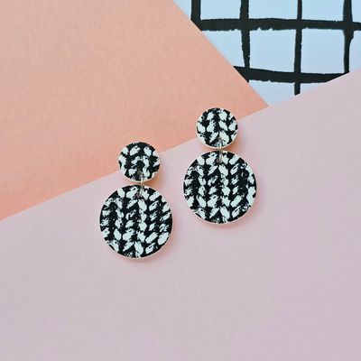 A pair of black and white knit print circle stud earrings.