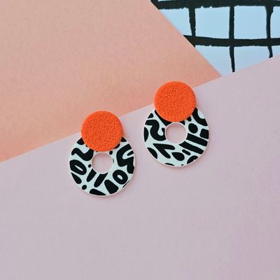 A pair of orange, black and white chunky hoop earrings