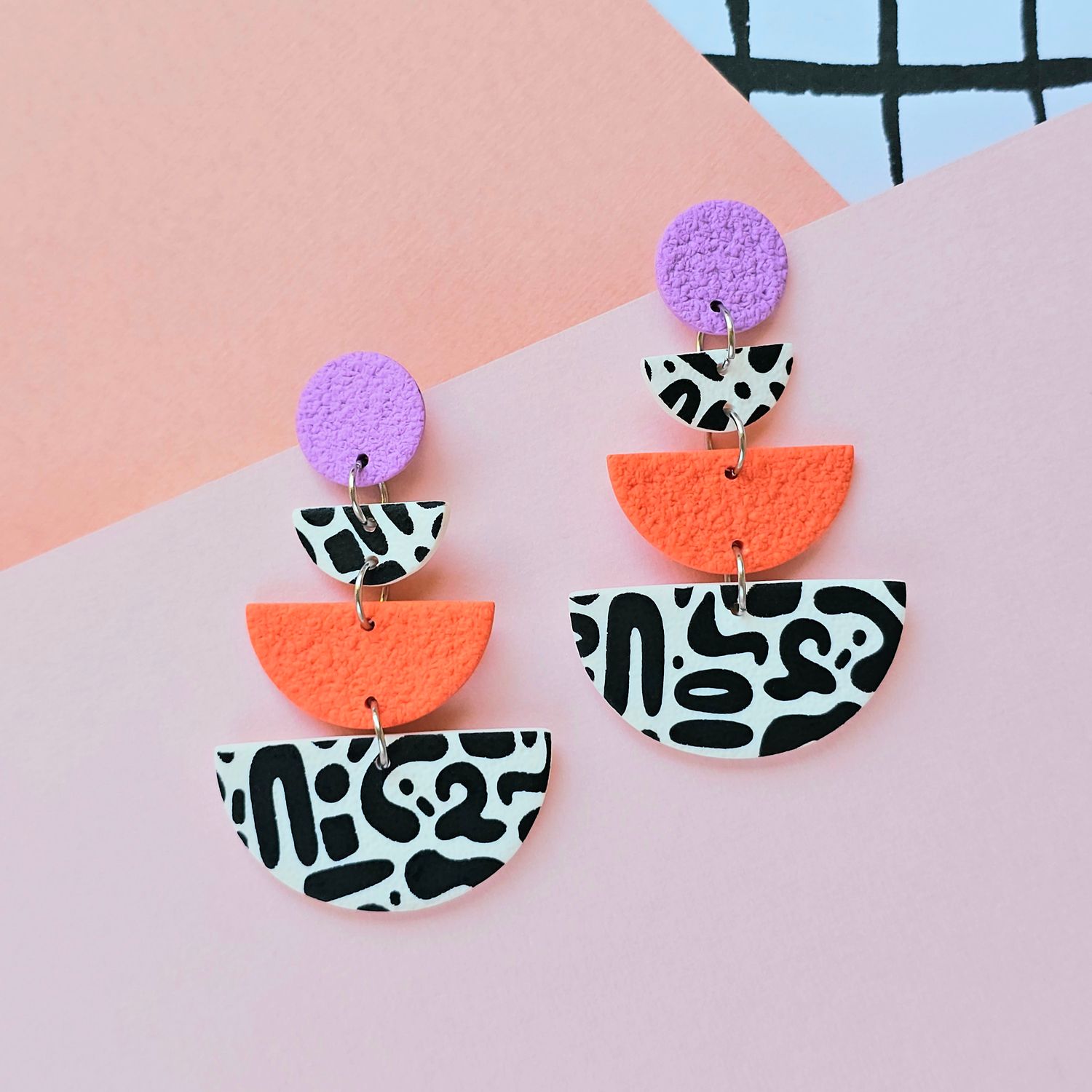 A pair of large orange purple fun printed semicircle earrings