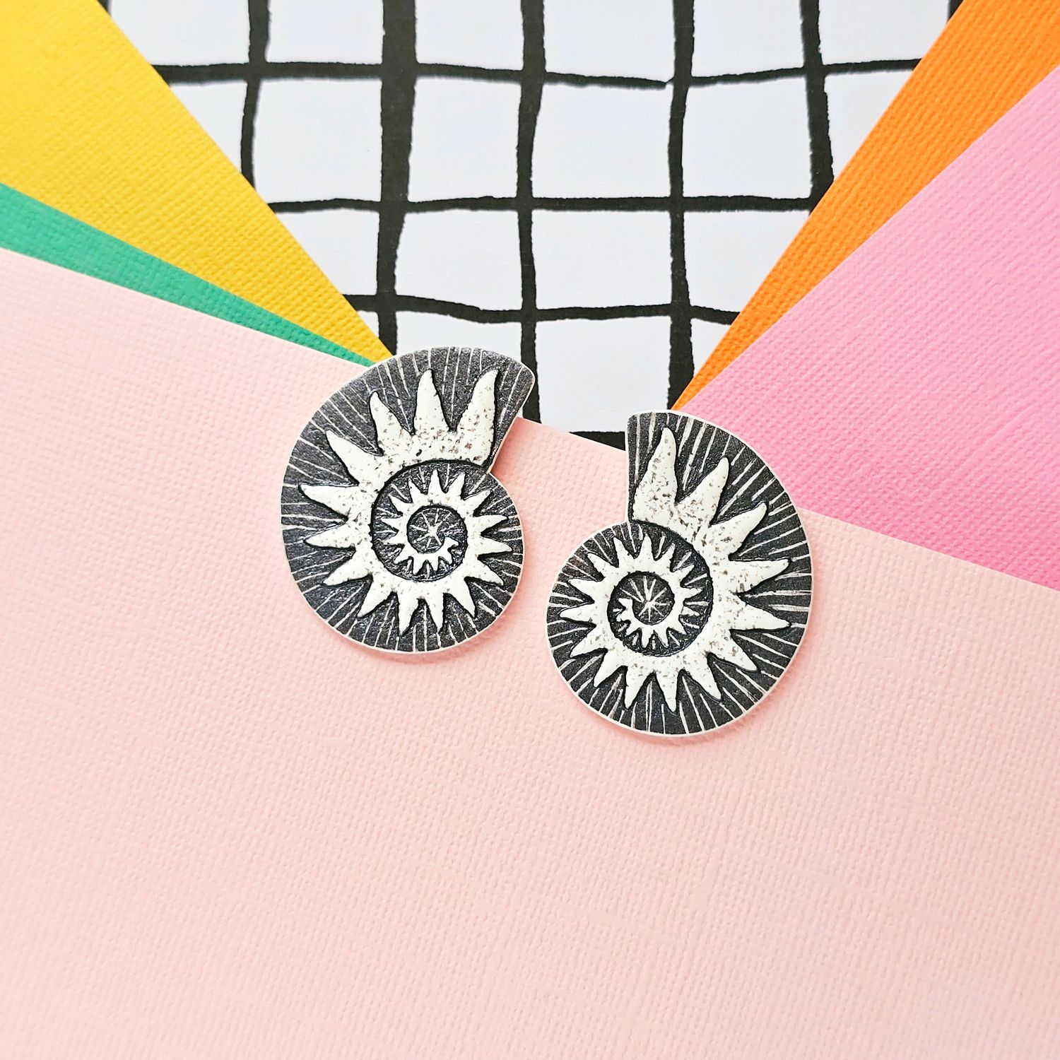 A pair of dark grey and white spiral faux ammonite polymer clay earrings.