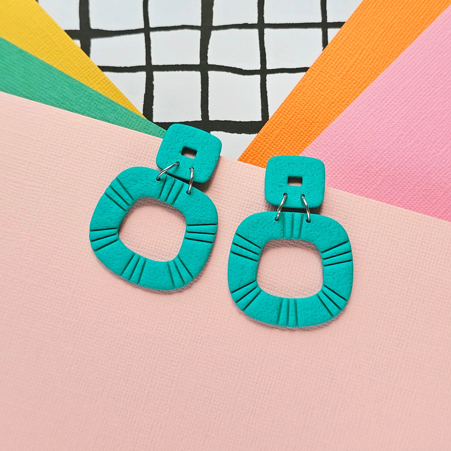 A pair of teal green statement polymer clay earrings