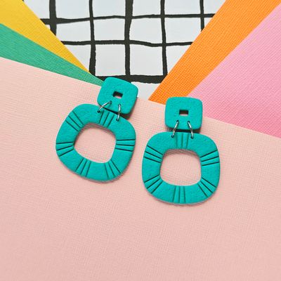 A pair of teal green statement polymer clay earrings
