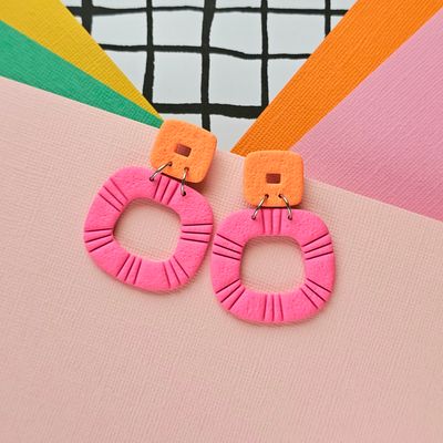 A pair of pink and orange statement hoop polymer clay earrings